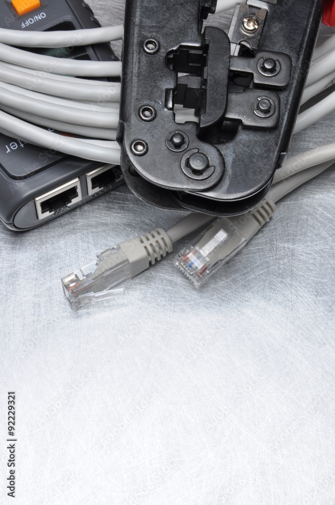 Network tester and crimping tool with RJ45 connector on metal background with place for text Network tester and crimping tool with RJ45 connector on metal background with place for text