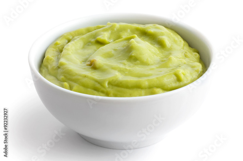 Round white bowl of tortilla guacamole dip isolated in perspecti photo