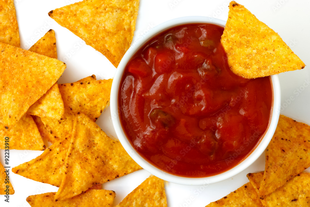 Round white bowl of tomato salsa dip with tortilla chips inside Round white bowl of tomato salsa dip with tortilla chips inside