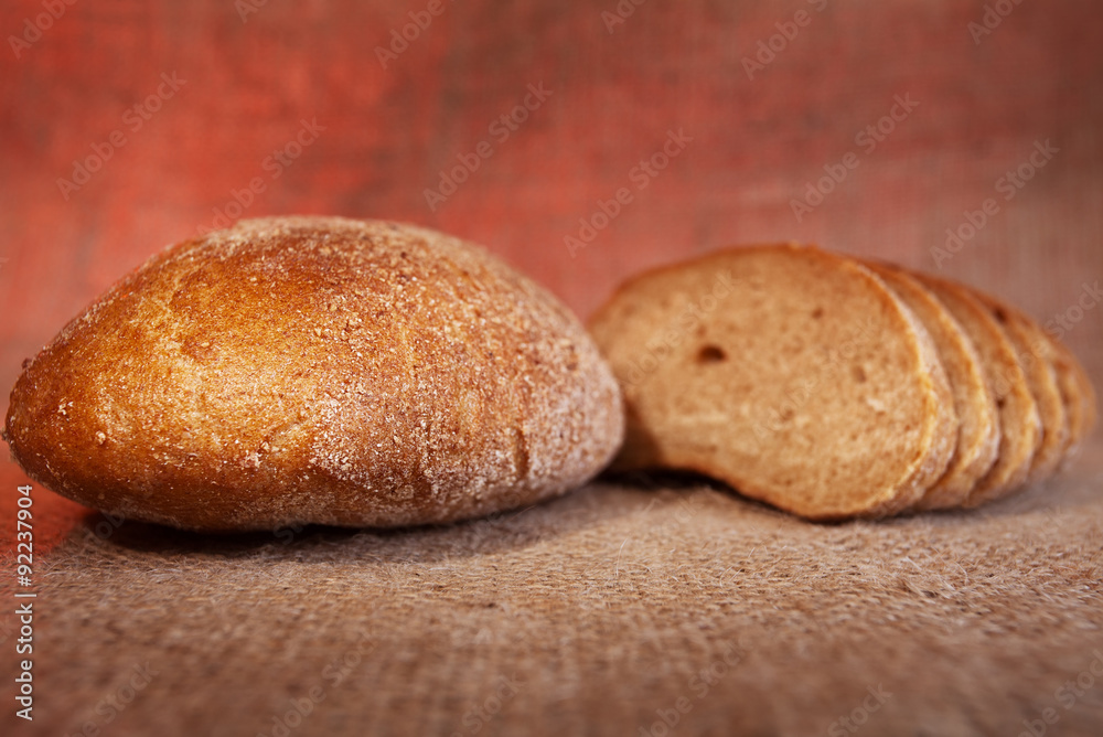 Black bread on sackcloth background. Selective focus Black bread on sackcloth background. Selective focus