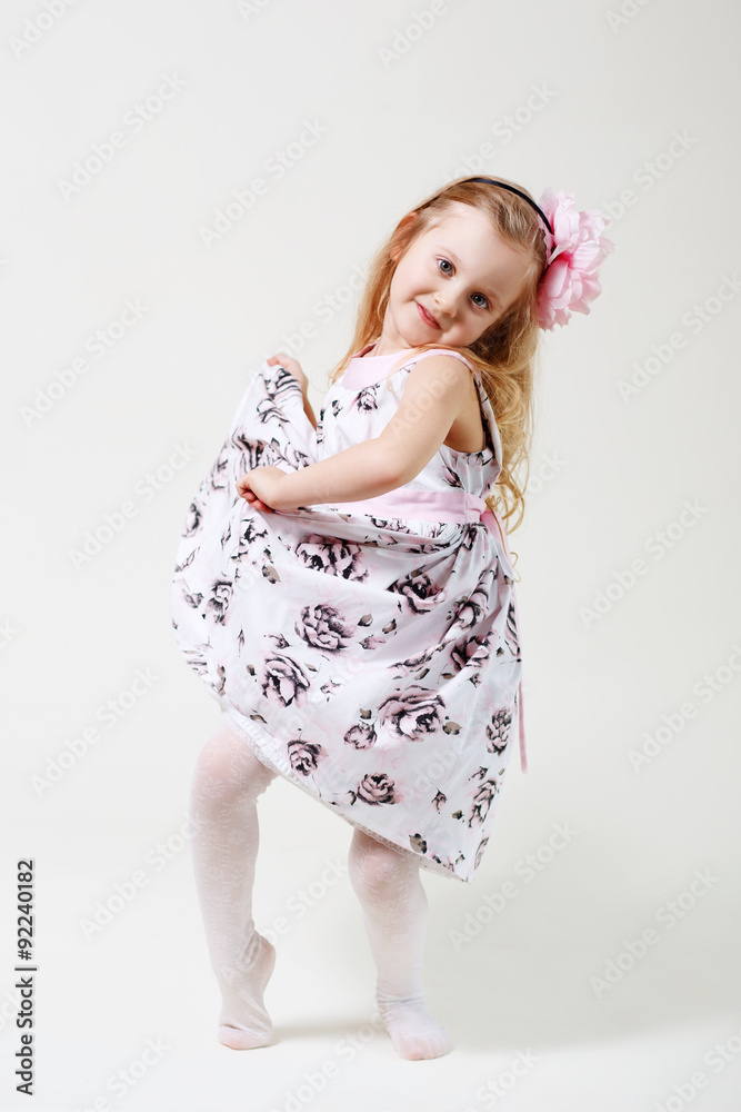 Fototapeta premium Full length portrait of a cute little blonde girl dancing
