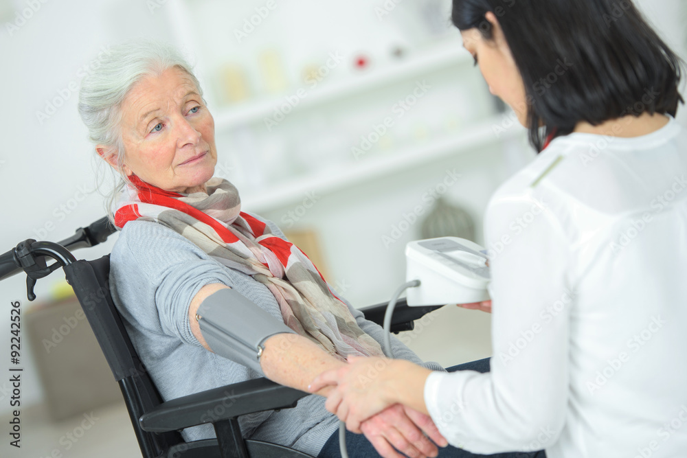 Fototapeta premium Checking an old lady's blood pressure