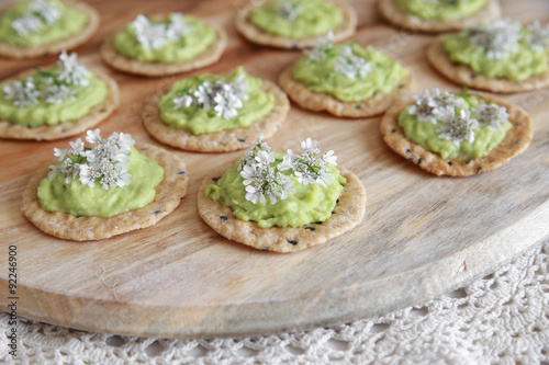 Green avocado crackers with coriander flowers