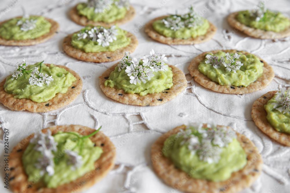 Green avocado crackers with coriander flowers