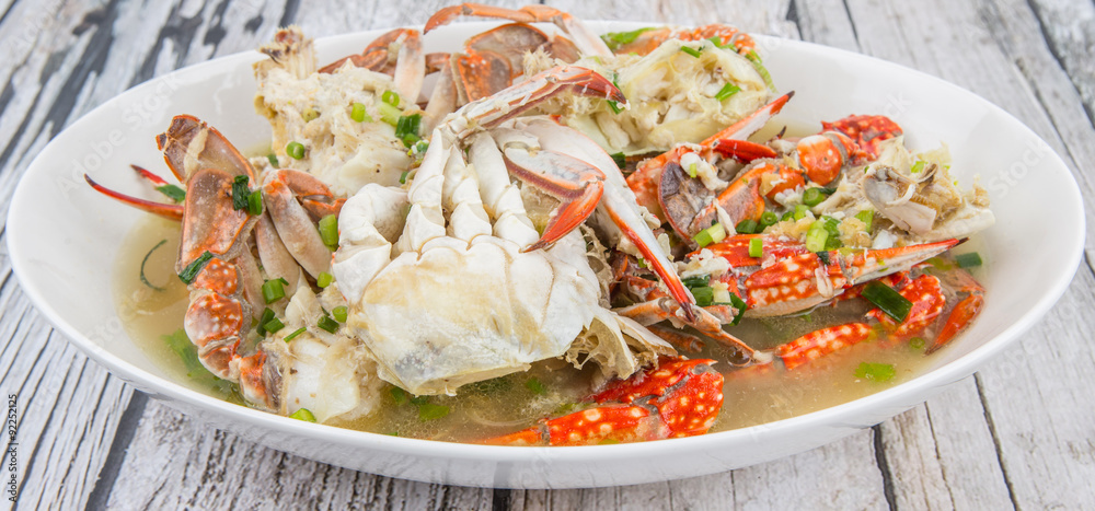 Malaysian dish clear crab soup in an oblong plate over wooden background