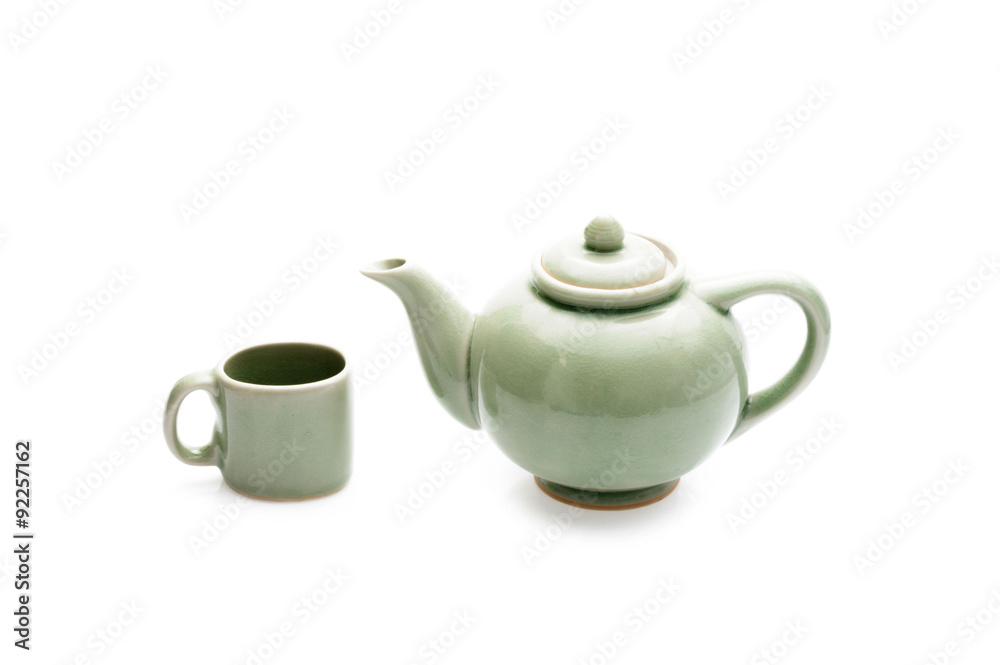 Close up green ceramic tea pot and cup on white background