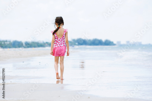 Little asian girl walk on the beach