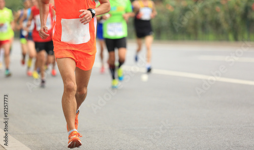Many marathon runners running on city road © lzf