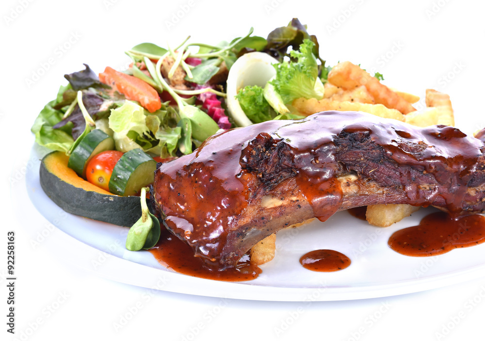 Rib steak served with salad on white background Rib steak served with salad on white background