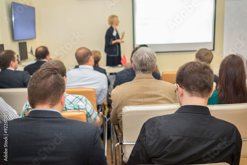 Female academic professor lecturing at faculty. Students at the lecture hall.