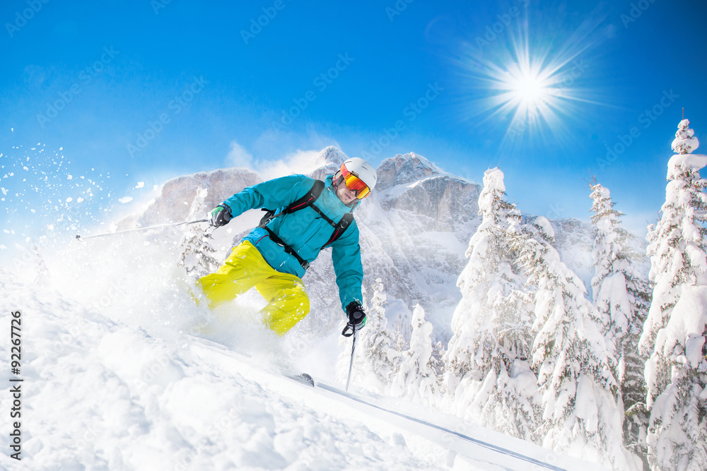 Skier skiing downhill in high mountains