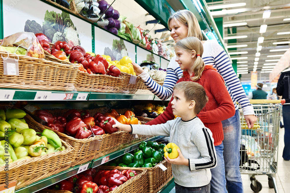 Mother and children with bell pepper in supermarket Mother and children with bell pepper in supermarket