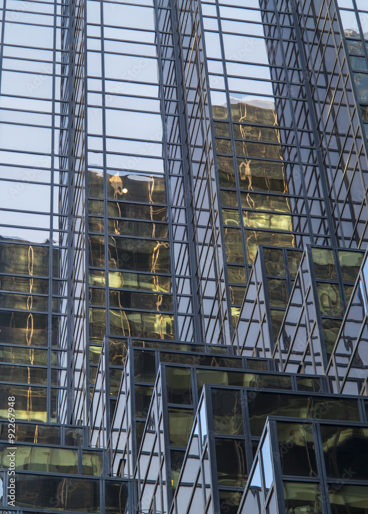 Modern tall building with blue glass facade and reflections in New York Manhattan