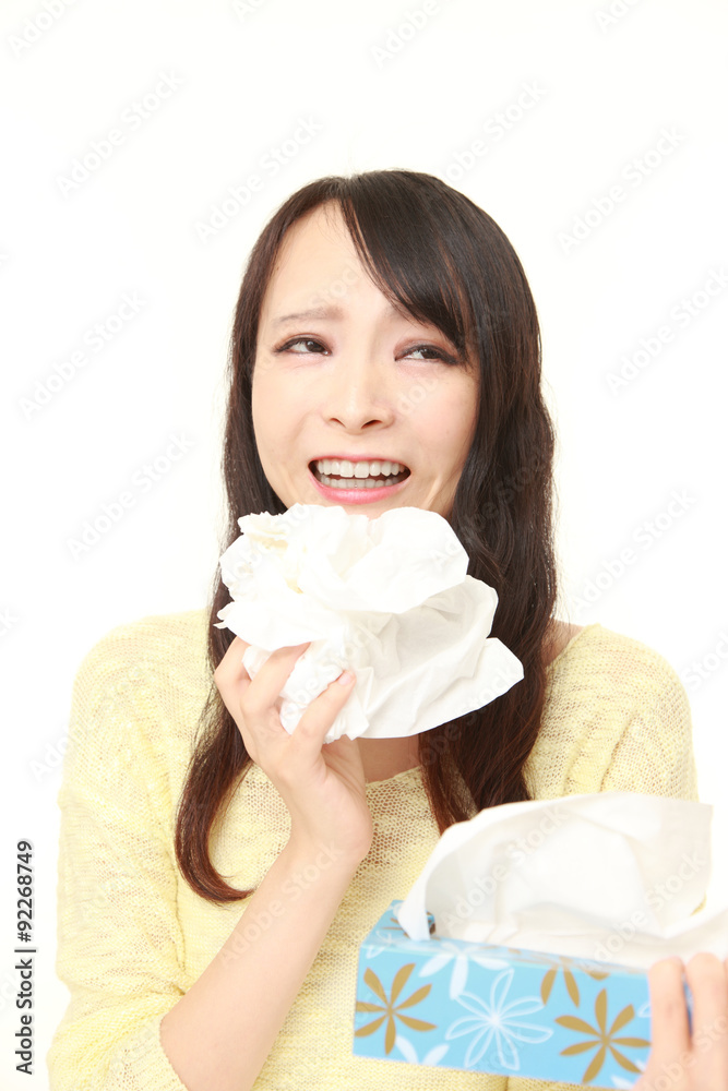 young woman with an allergy sneezing into tissue young woman with an allergy sneezing into tissue