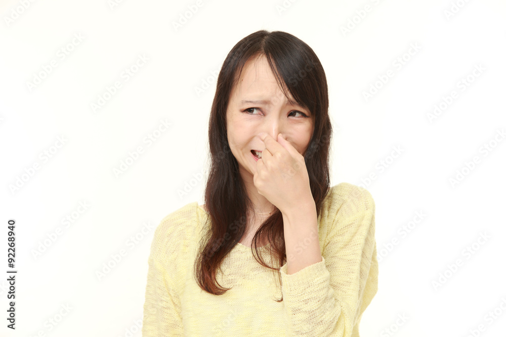 Japanese woman holding her nose because of a bad smell Japanese woman holding her nose because of a bad smell