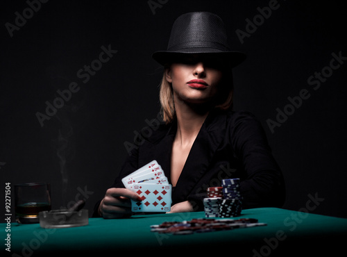 Beautiful young woman playing poker photo