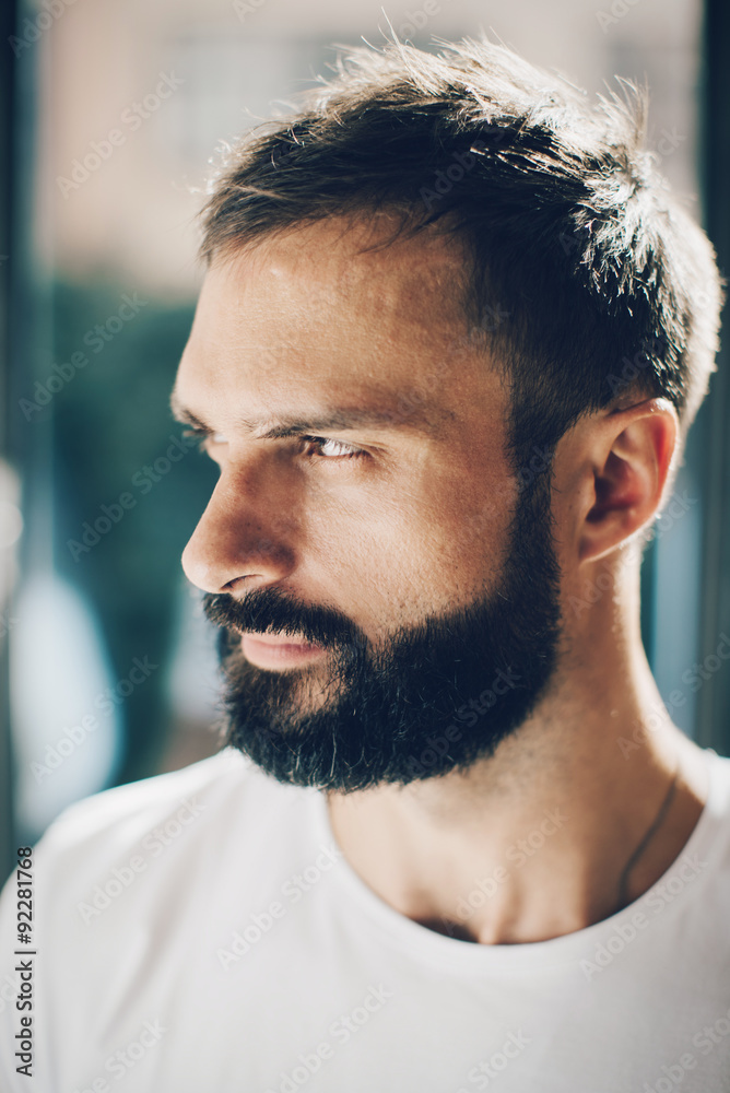 Fototapeta premium Portrait of a bearded man looking out the window
