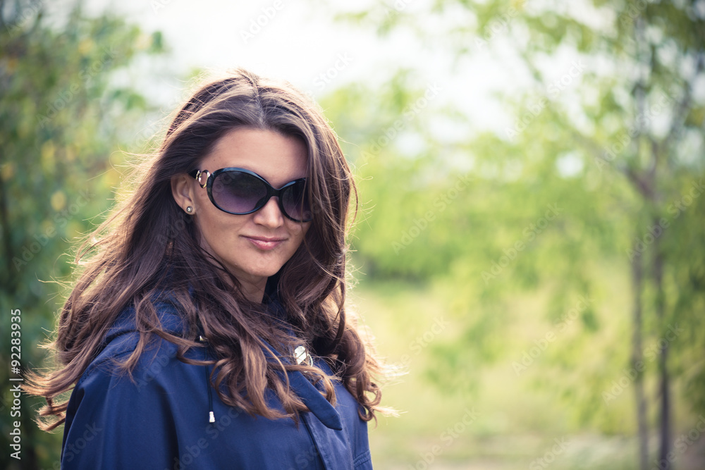 Woman in blue jacket in green summer park Woman in blue jacket in green summer park