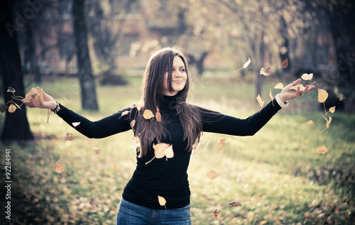 young woman throwing leaves woman in the forest