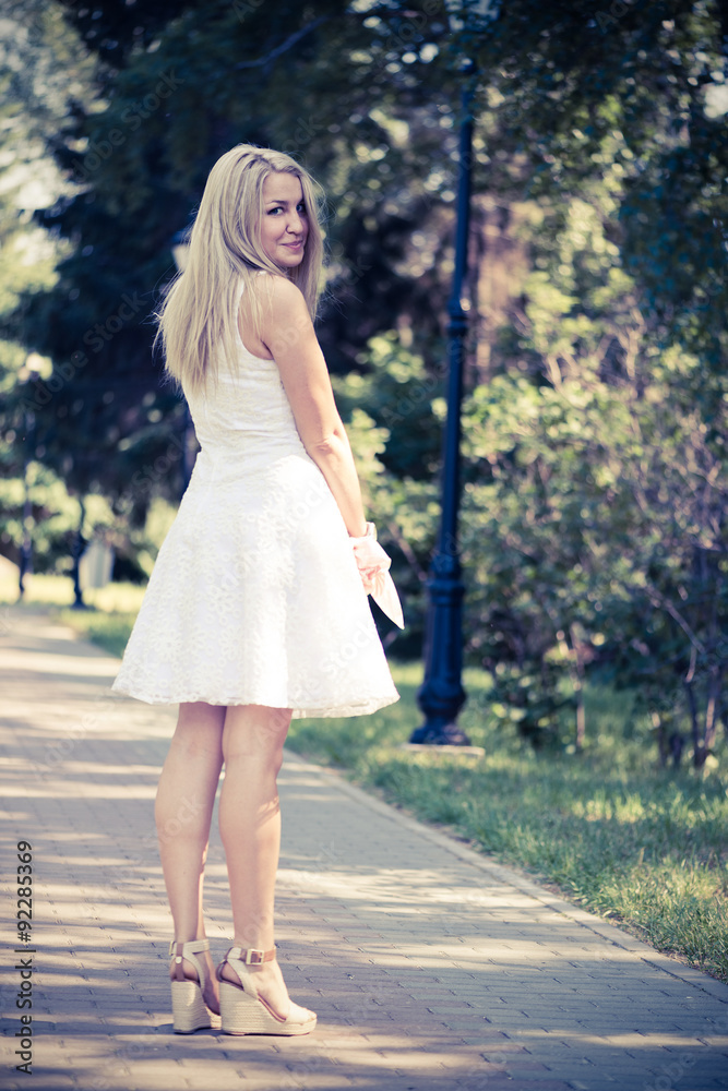 Beautiful young blond woman in a white dress outdoors Beautiful young blond woman in a white dress outdoors
