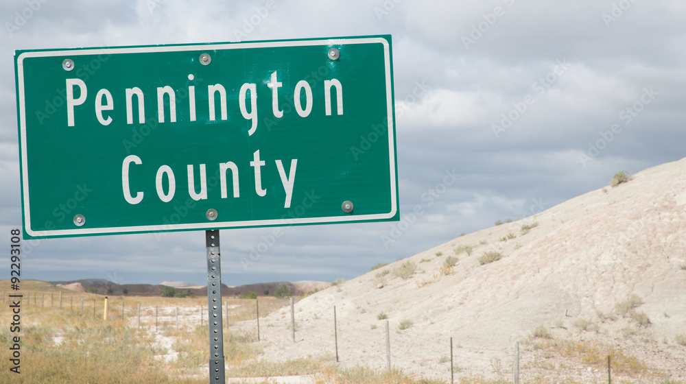 Highway sign marking the eastern boundary of Pennington County, South Dakota in the Badlands on Highway 44