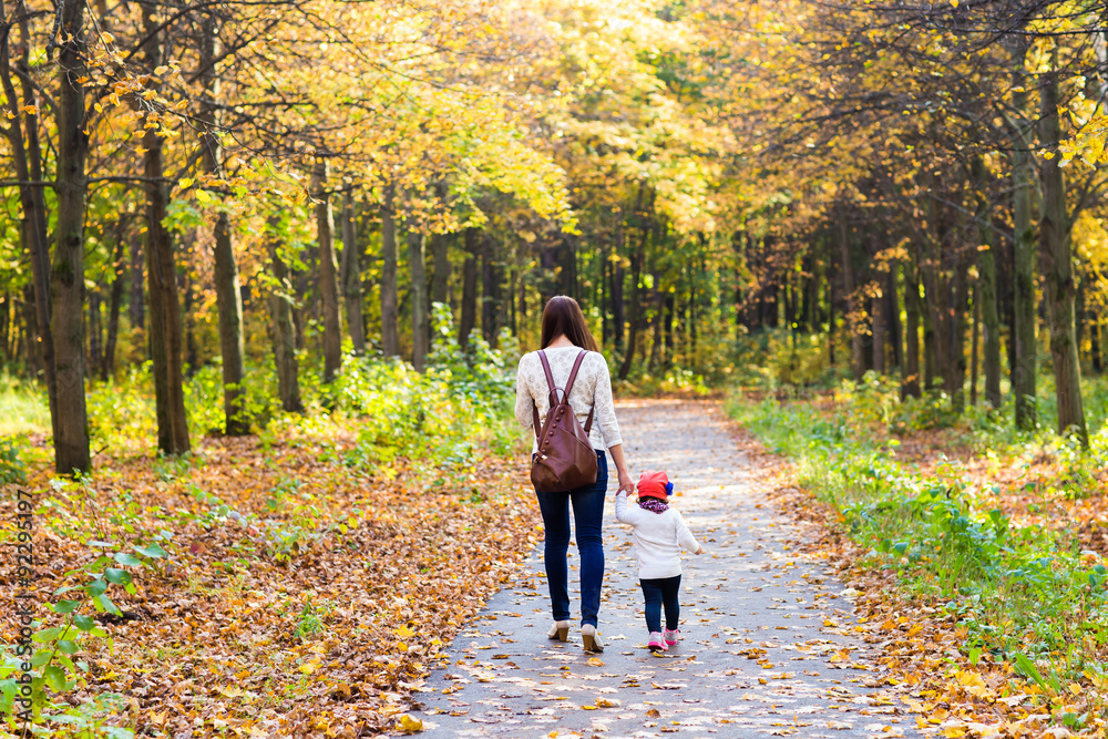 Fototapeta premium Young mother walking with her baby in an autumn park