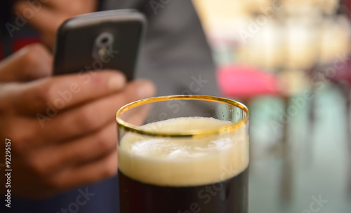 Man using smartphone picturing glass of a beer