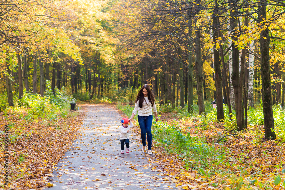 Young mother walking with her baby in an autumn park Young mother walking with her baby in an autumn park