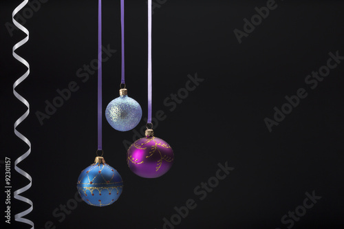 Hanging colorful christmas balls on black background
