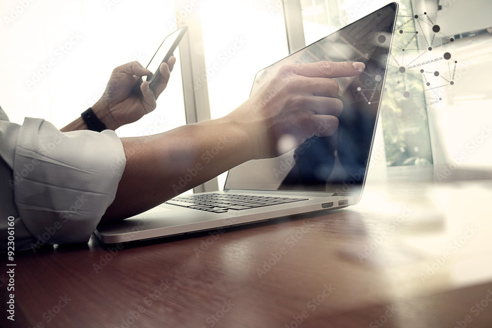 Obraz premium projektant pracy ręcznej i inteligentny telefon i laptop na drewnianym biurku