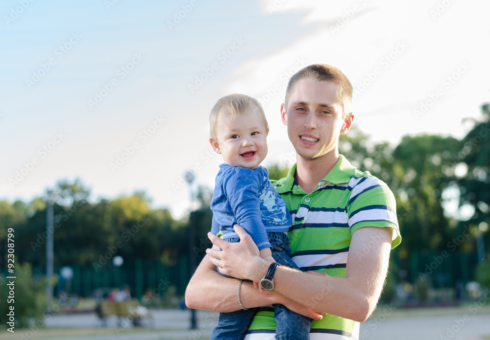 Fototapeta premium young father is holding his little son