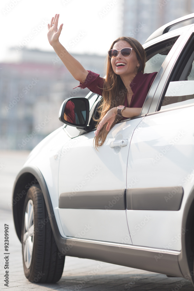 Beautiful lady waving from her car