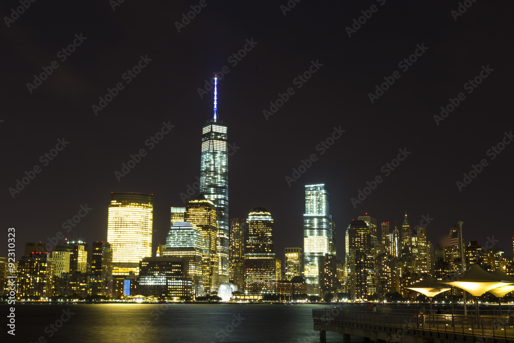 Waterfront walkway and view of the Exchange Place in Jersey City, New Jersey at night