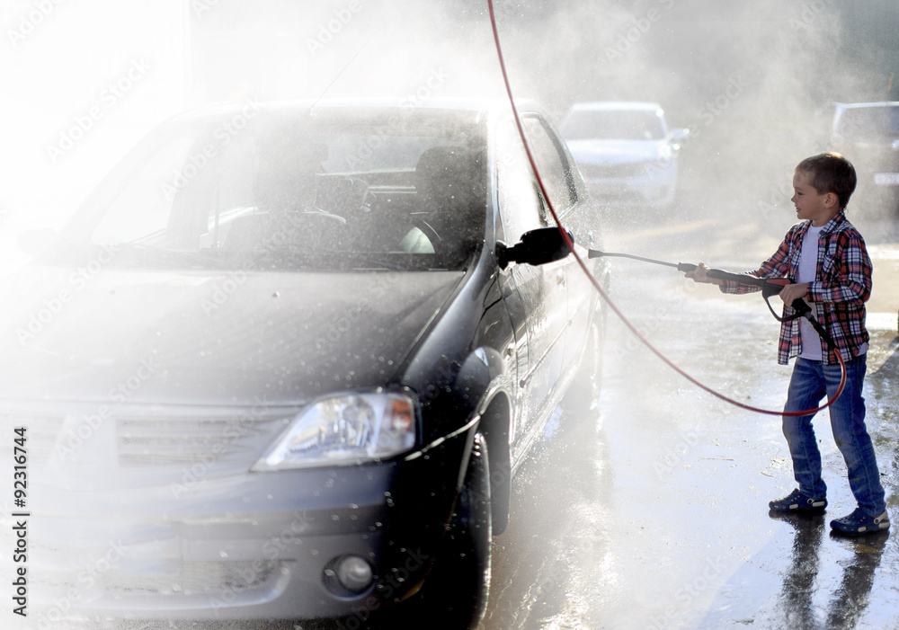 self washing car at the car wash. boy washing a car with a rubber hose