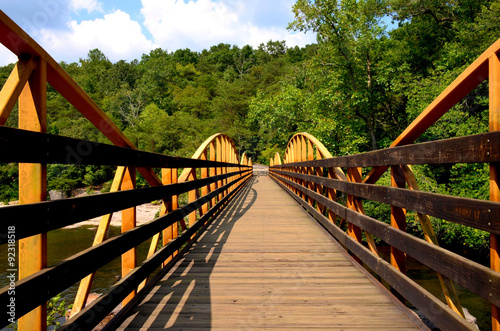 Fototapeta Naklejka Na Ścianę i Meble -  Walking hiking bridge in the woods.  Footpath over river.