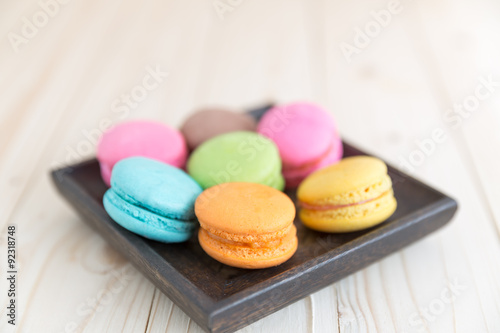 Macarons in a dish on a wood background