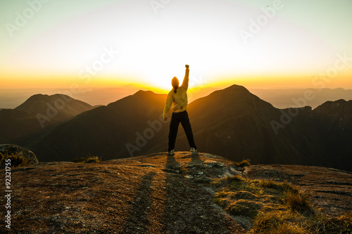 Man celebrating success on top of a mountain