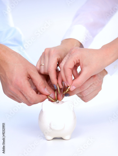 People putting coin into the piggy bank