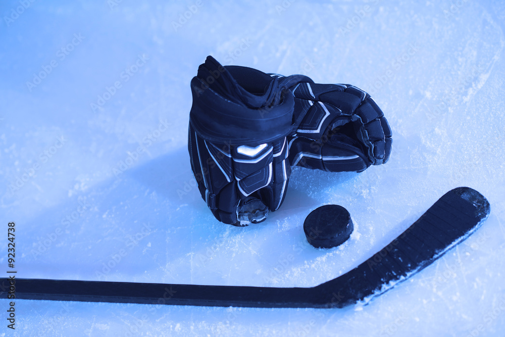 Naklejka premium hockey sticsk and puck on ice