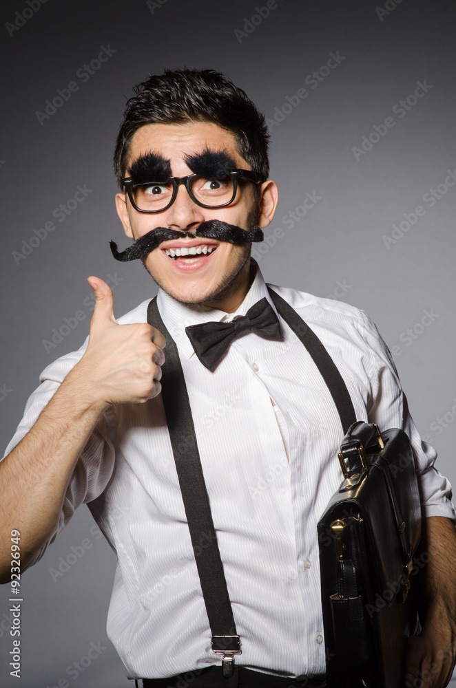 Fototapeta premium Young caucasian man with false moustache against gray