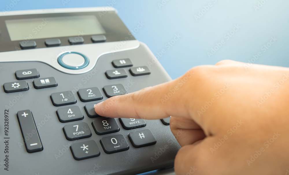 hand is dialing a phone number with picked up headset hand is dialing a phone number with picked up headset