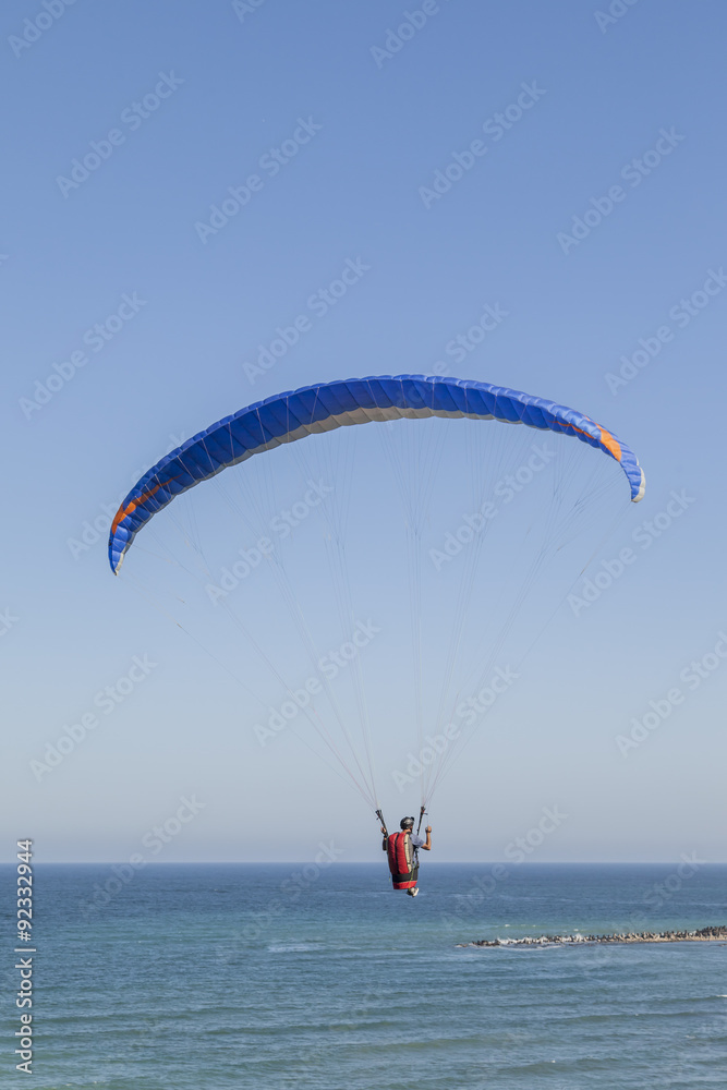 Paraglider hovers above the sea