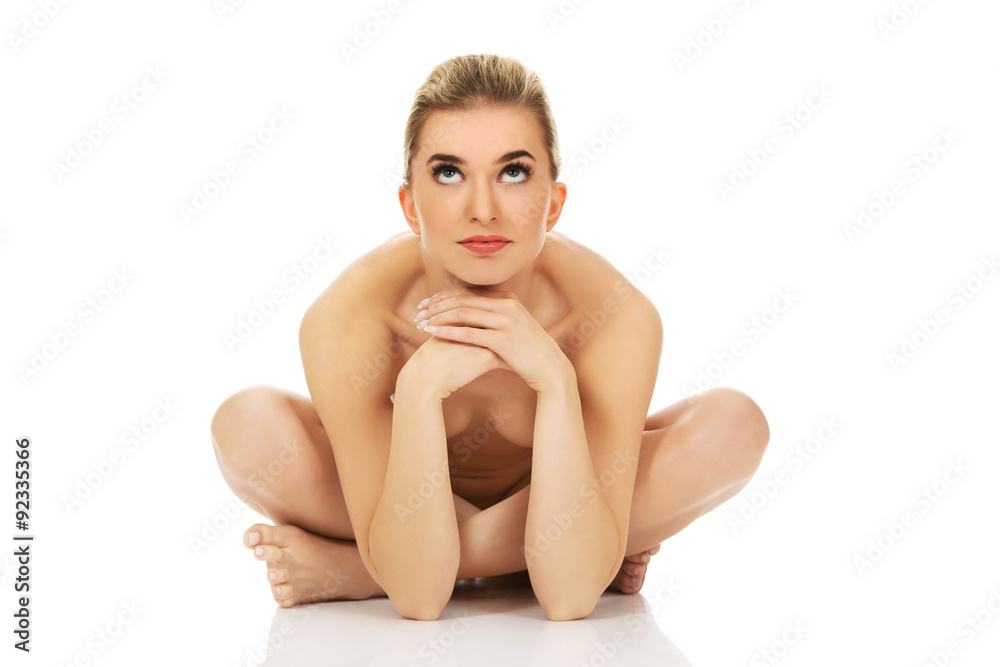 Obraz premium Young naked woman sitting on the floor
