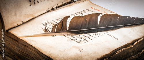 Open old book with a quill pen clous up photo