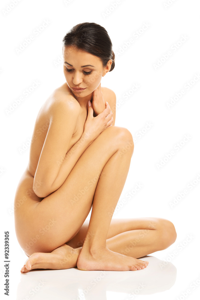Topless woman sitting with knee close to chest Topless woman sitting with knee close to chest