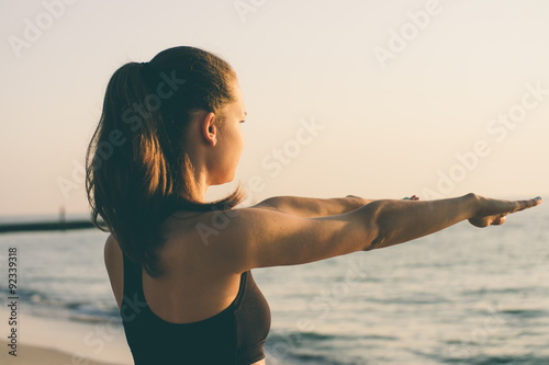 Valokuva Young woman doing morning exercises at the beach