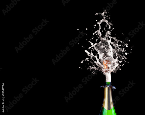 popping champagne bottle on black background. celebration, party and new year concept.