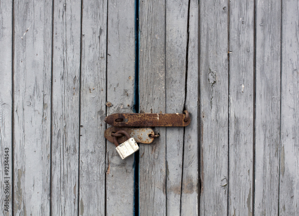 Old wooden door with padlock. Old wooden door with padlock.