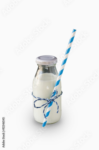 Milk bottle with striped straw isolated on white photo