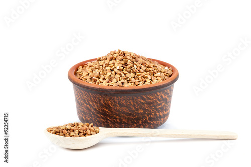 Buckwheat in a ceramic bowl and a wooden spoon.